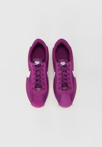Ljubičaste Nike tenisice s dizajnom od antilopa i mreže, s bijelim akcentima u obliku swoosh, ravnim vezicama i zaobljenim vrhom.