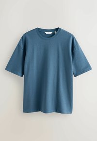 T-shirt en coton texturé bleu à manches courtes avec encolure ronde, taille moyenne indiquée par la marque NEXT, présenté sur un fond uni.