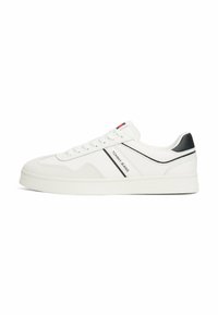 Zapatillas blancas de corte bajo hechas de cuero liso, con un acento negro y el logo "TOMMY JEANS". Suela plana de goma con un acabado texturizado.