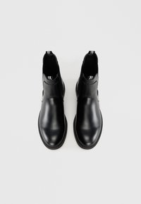 Botas negras de cuero hasta el tobillo con paneles laterales elásticos, punta redonda y detalles de costura sutiles. Textura suave y diseño minimalista.