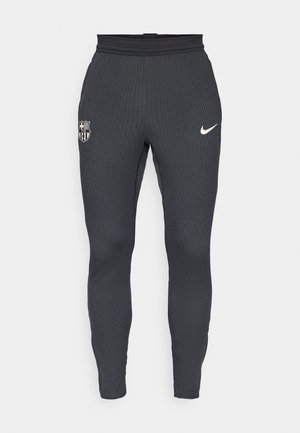 Gray athletic pants made of ribbed fabric with a fitted design. Features a Nike logo and an FC Barcelona crest on the left leg.