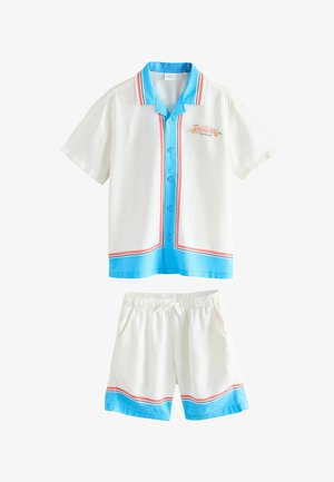 Hvid kortærmet skjorte med knapper og shorts sæt med blå og rød kant, teksten "Riviera Côte d'Azur" på skjortens bryst.