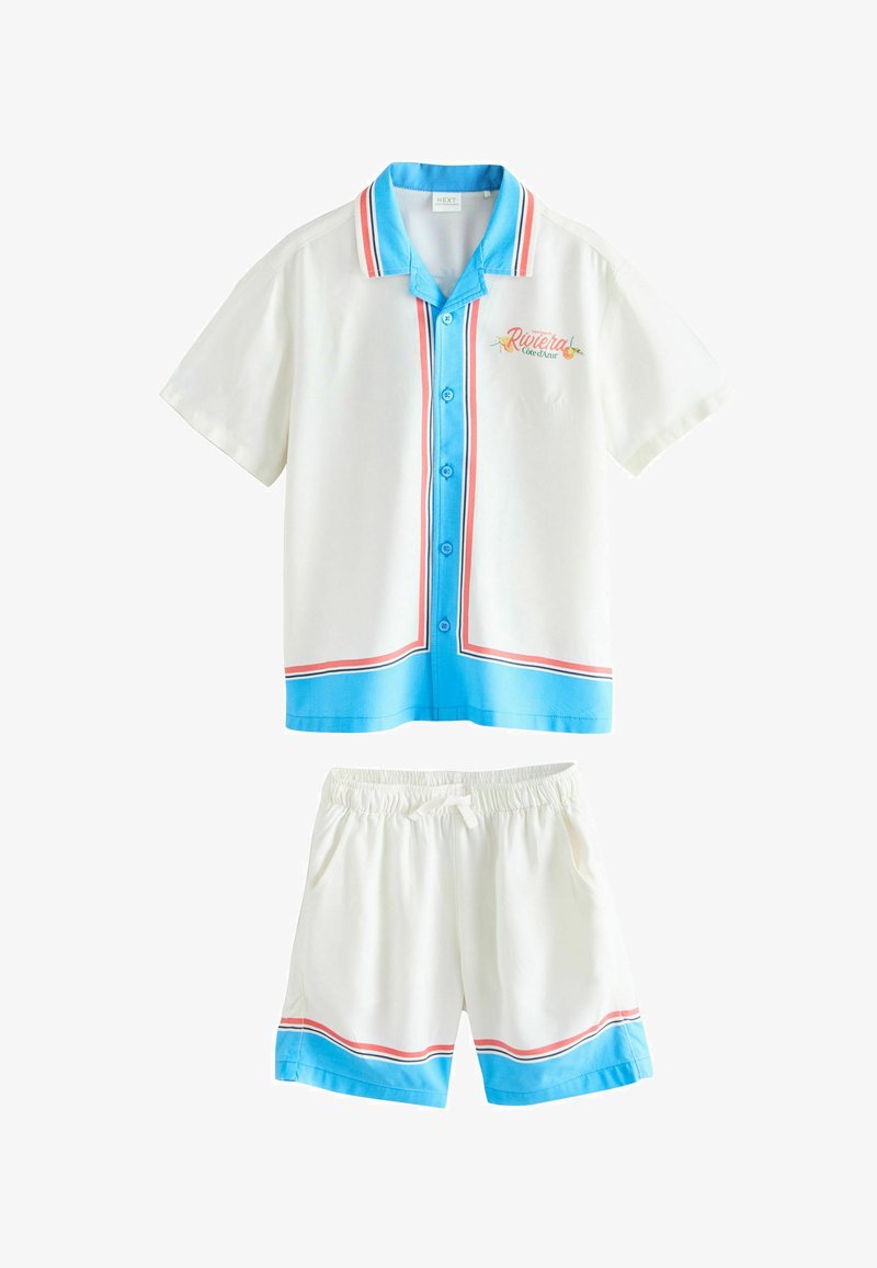 Ensemble chemise blanche à manches courtes boutonnée et short avec bordures bleues et rouges, texte « Riviera Côte d'Azur » sur la poitrine de la chemise.