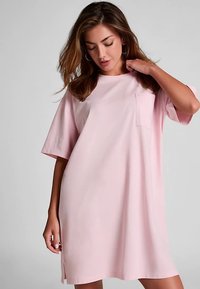 Világos rózsaszín, bő fazonú pólóruha rövid ujjal, kerek nyakkal és egy kis zsebbel a bal mellrészen. Simább anyagtextúra.