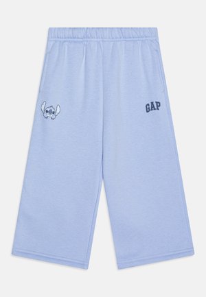 Pantalones cortos de sudadera azul claro con una cintura elástica, que presentan un gráfico del personaje Stitch y el logo "GAP" en azul oscuro en el lateral.