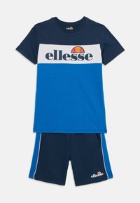Den blåa och marinblå atletiska uppsättningen inkluderar en kortärmad T-shirt med en färgblockdesign och logotyp, tillsammans med matchande shorts med sidodetaljer.