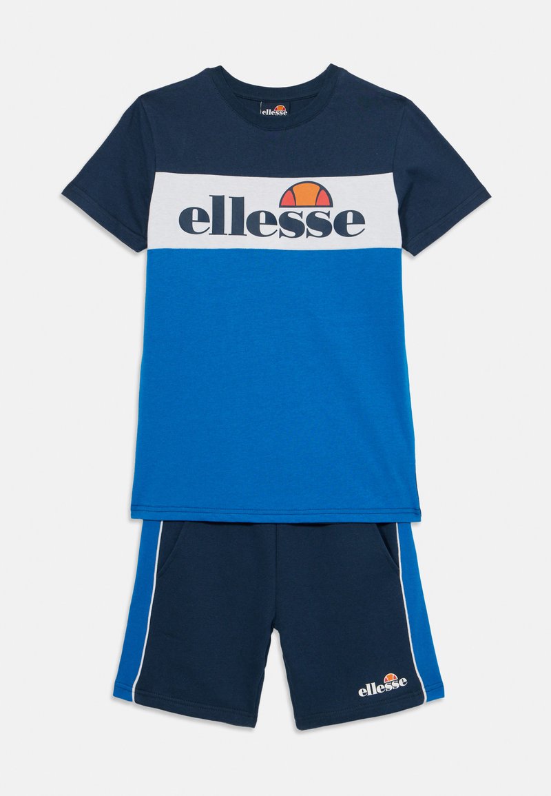 Det blå og marineblå atletiske sæt inkluderer en kortærmet T-shirt med et farveblokdesign og logo, der er parret med matchende shorts med sidelogo.