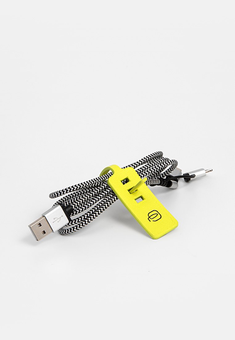 Vlechtbare USB- en audiokabel, met een zilveren connector, een zwart-wit gestreepte textuur en een heldergele plastic clip voor organisatie.
