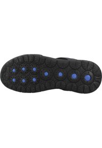 Suela de zapato negra con goma texturizada, con patrones circulares y acentos circulares azules. Bordes lisos, con surcos ligeramente elevados para mayor agarre.