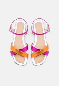 Sandály s pásky v růžové a oranžové metalické barvě, čtvercová špička, plochá podrážka a minimalistický kotníkový pásek se stříbrnou sponou.