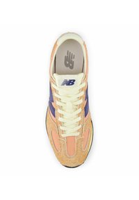 New Balance Sneaker mit orangefarbenem und lila Wildleder-Obermaterial, weißen Schnürsenkeln und Logodetails an Zunge und Seite. Gepolstertes Innenfutter für Komfort.