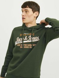 Sudadera de algodón verde con un gráfico frontal en blanco y naranja. El diseño incluye un bolsillo canguro y capucha con cordón.