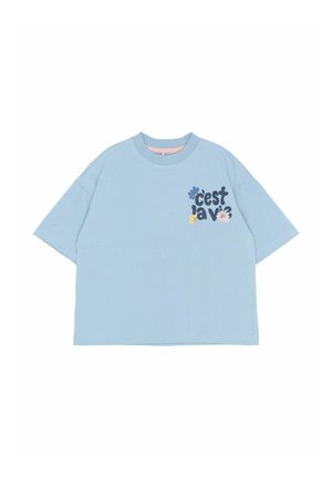 Sky blue oversized t-shirt with short sleeves, featuring "c'est la vie" text and colored flower graphics on the front. Smooth fabric texture.