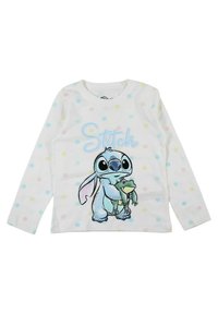 Chemise blanche à manches longues avec des pois multicolores. Présente un motif de Stitch tenant une grenouille, avec le texte "Stitch" en bleu.