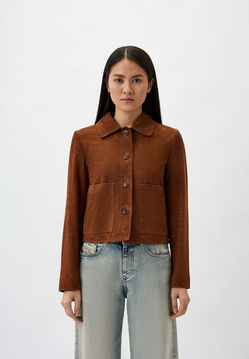 Bruine suède cropped jas met een kraag, sluiting met knopen aan de voorkant en twee opgestikte zakken. Gekocht over lichtblauwe denim jeans.