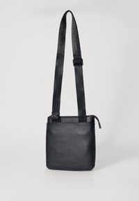 Borsa a tracolla nera in pelle con tracolla regolabile e texturizzata, forma rettangolare, chiusura con zip nella parte superiore e design minimalista.