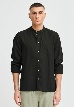 Black button-up shirt with a stand collar, single chest pocket, and rolled-up sleeves, made from a textured fabric.