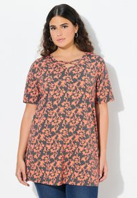 Top con estampado floral que presenta un fondo gris con flores naranjas, mangas cortas y un escote en V con detalle entrelazado. Tejido suave.