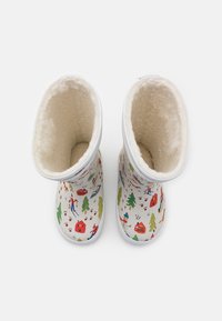 Børns hvide vinterstøvler med fleece-for, dekorert med farverige vintermotiver, herunder skiløbere, træer og hytter.