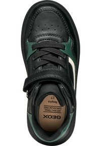Sneaker en cuir noir avec des accents verts et blancs. Présente un col rembourré, des lacets à l'avant et une sangle Velcro pour une fermeture sécurisée.