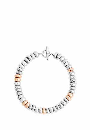 Runde Silber- und Roségoldperlen auf eine Armband mit rundem Knebelverschluss auf weißem Hintergrund aufgefädelt.