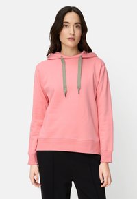 Pink hooded sweatshirt with drawstrings, cuffed sleeves, and a relaxed fit. Smooth fabric with a subtle sheen and a kangaroo pocket.