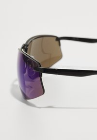 Sonnenbrille mit schwarzem Rahmen, gewölbten Gläsern, die von Lila zu Braun übergehen, und schlanken Bügeln. Leichtes Design ohne sichtbare Markenkennzeichnung.
