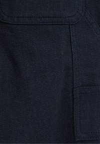 Mörkblått tyg med en texturerad väv, med en lapplomme och rena, raka kanter. Hållbart material lämpligt för arbetskläder.