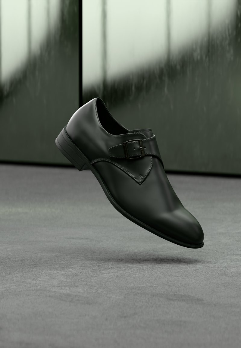 Μαύρο δερμάτινο παπούτσι με λεία υφή, στρογγυλεμένη μύτη, διακοσμητική αγκράφα στο πλάι και χαμηλό τακούνι, τοποθετημένο πάνω σε γκρι επιφάνεια.