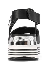 Sandalo nero con cinturini dal design elegante, con un accento argentato lucido sul tallone e una suola a righe bianche e nere in contrasto.