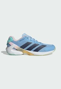 Light blue athletic shoe with mesh upper, dark blue stripes, pink accents, and a contrasting white and translucent sole. Textured design with padded collar.