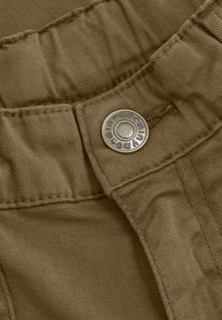 Khaki stoffen tailleband met subtiele textuur, voorzien van een zilveren knop met de opdruk "minymo" en steraccenten. Gestikte details zichtbaar.