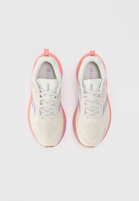 White athletic shoes with pink-orange soles, mesh upper, purple accents, and flat laces. Designed for comfort and breathability.