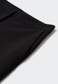 Pantalons noirs ajustés avec une texture lisse, des plis soignés et un ourlet replié. Fabriqués en tissu léger, arborant un design classique.