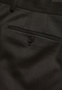 Czarne spodnie materiałowe o gładkiej fakturze, z tylną kieszenią zabezpieczoną okrągłym czarnym guzikiem. Dopasowany krój z estetycznym przeszyciem.