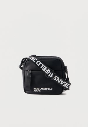 Geantă crossbody dreptunghiulară neagră cu buzunar frontal, logo alb „KARL LAGERFELD JEANS” și curea reglabilă cu text alb cu marcă.