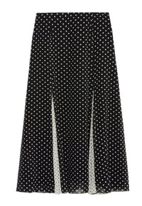 Jupe noire à pois blancs, avec un design fluide et des fentes latérales, fabriquée en tissu léger, présentant une texture douce.