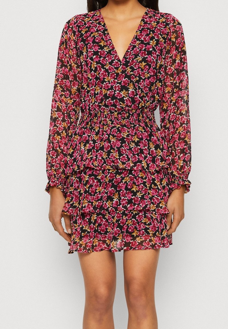 Blommig minikjol med svart bakgrund, genomskinligt tyg, djup V-ringning, långa ärmar, elastisk midja och lager av volangkant.