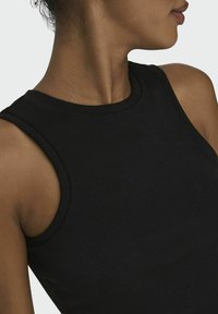 Zwarte geribbelde tanktop met een ronde halslijn en brede schouderbanden, die een nauwsluitend ontwerp met een zachte textuur benadrukt.