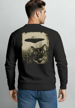 Black sweatshirt featuring a cat's face with large eyes, surprised expression, and a UFO above, all in a distressed beige print.