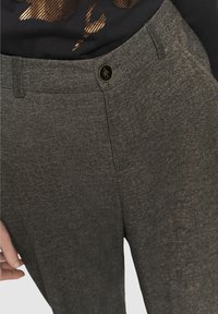 Pantaloni grigi con texture e design dritto, caratterizzati da chiusura frontale con bottone, tasche laterali e dettagli a vista sulle cuciture delle tasche.