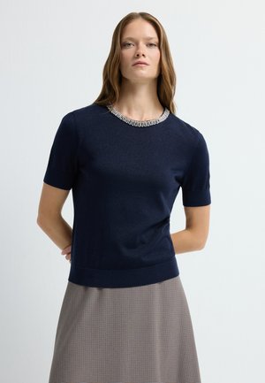 Granatowy sweter z krótkim rękawem o teksturowanym wykończeniu, z kołnierzem ozdobionym przezroczystymi cyrkoniami i dopasowanym dolnym wykończeniem.