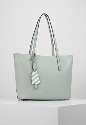 Jasnozielona skórzana torba na ramię z podwójnymi paskami i zawieszką w paski w kształcie loda, wiszącą na jednym z pasków.