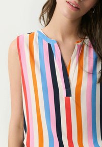 Sleeveless blouse in multi-colored vertical stripes, featuring blue, pink, orange, and navy. Has a V-neck and soft fabric texture.