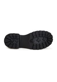 Semelle de botte noire avec des crampons profonds et des motifs en forme d'étoile, conçue pour la traction et la durabilité.