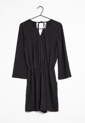Completo nero con maniche lunghe, scollatura a forma di chiave, vita arricciata e texture liscia, appeso a un gancio nero contro uno sfondo bianco.