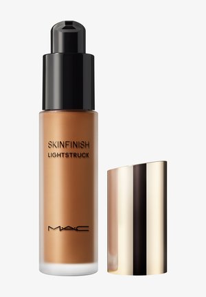 MAC Skinfinish Lightstruck vloeibare foundationfles met zwarte pompdispenser en verwijderde gouden dop op een witte achtergrond.