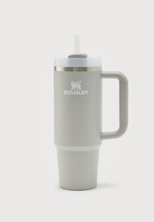 Gourde de voyage Stanley gris clair avec poignée, couvercle blanc et paille sur fond blanc.