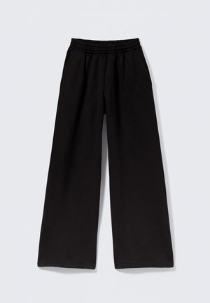 Pantalon noir à jambes larges en tissu doux, doté d'une taille élastiquée et de poches latérales. Texture lisse avec des coutures nettes et soignées.