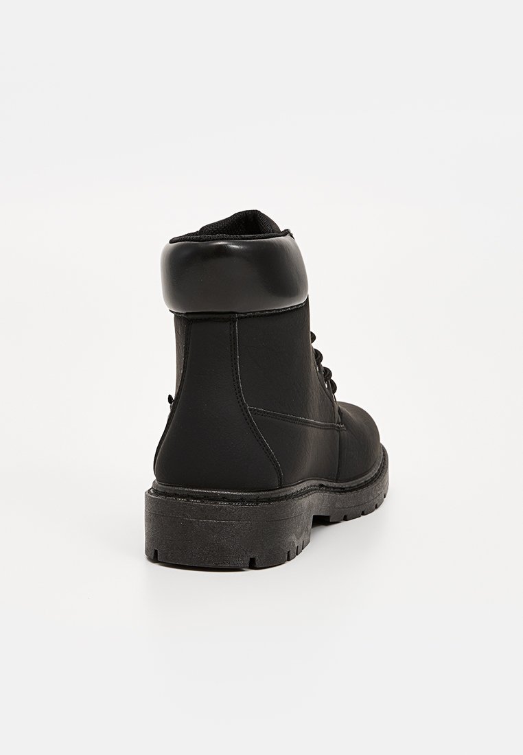 Bottines noires en cuir avec un col rembourré, un bout rond et une semelle en caoutchouc texturé. Présente un laçage à l'avant et un design robuste.